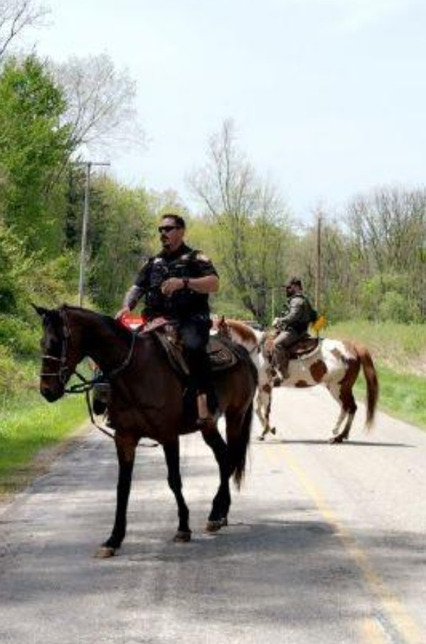 Lieutenant Craig Ritz on Cause with rescue horse Mercedes behind them